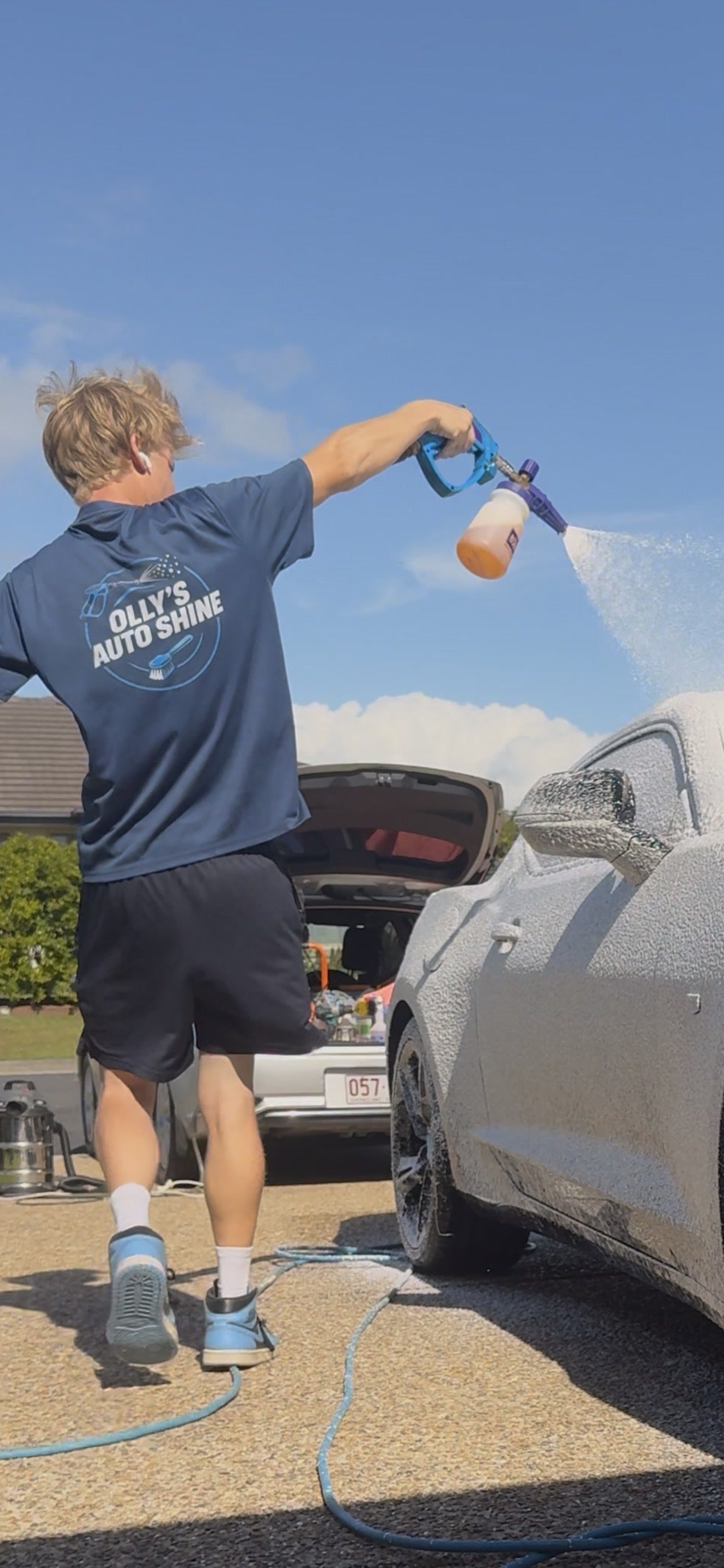 Olly foam-washing a customer's car on their driveway