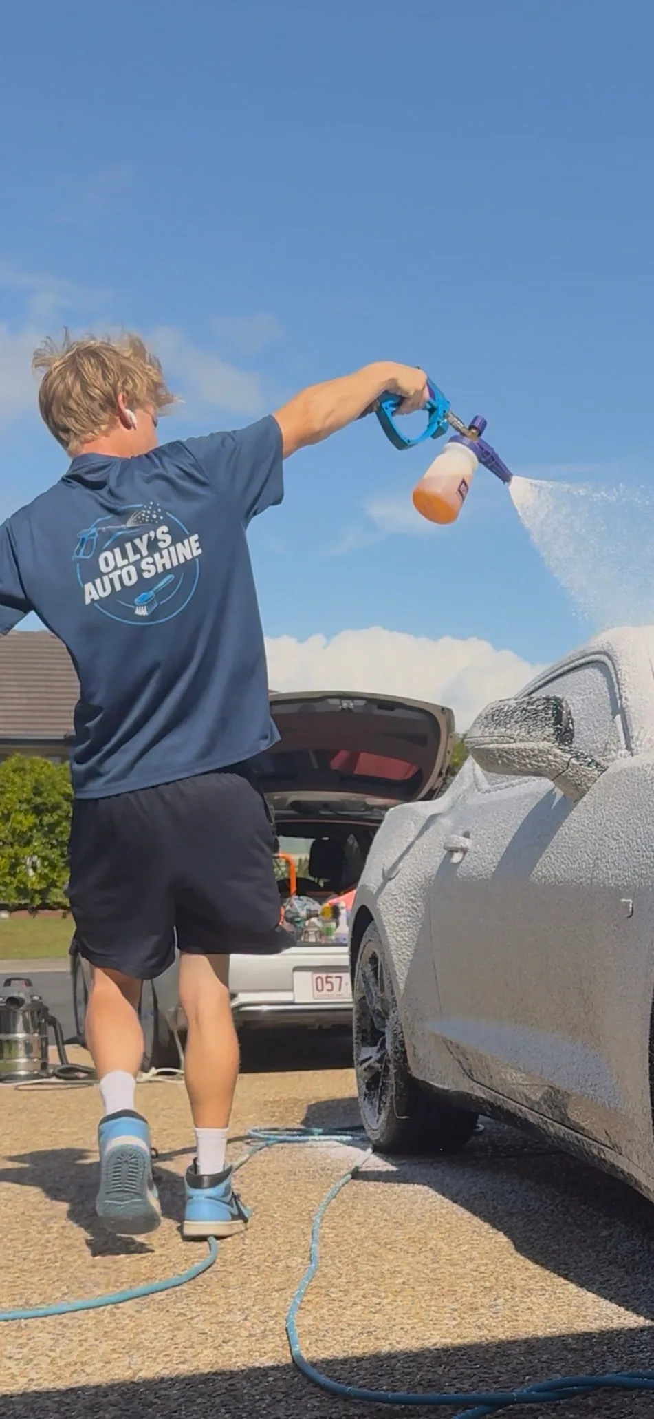 Olly foam-washing a customer's car on their driveway