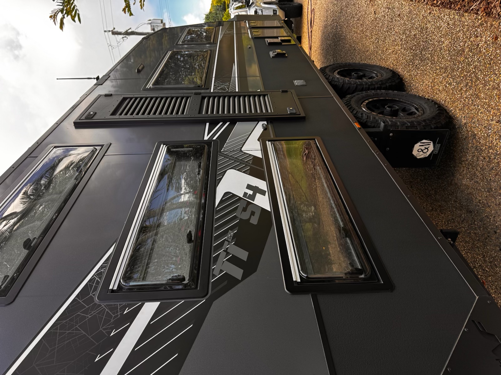 Clean exterior and polished windows along a black off-road caravan