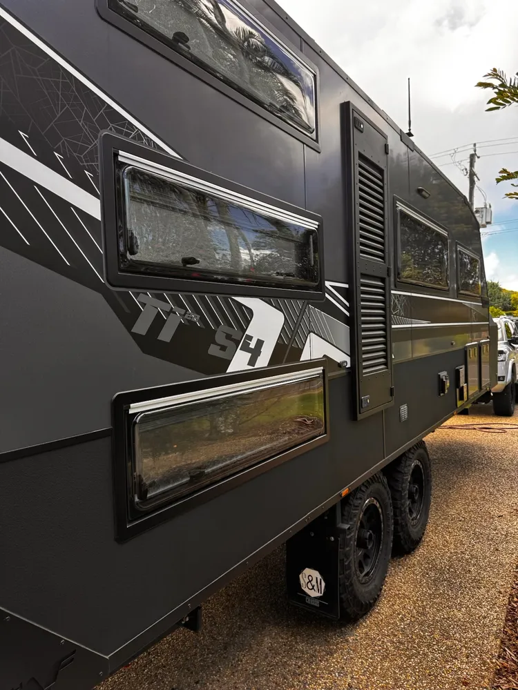 Clean exterior and polished windows along a black off-road caravan