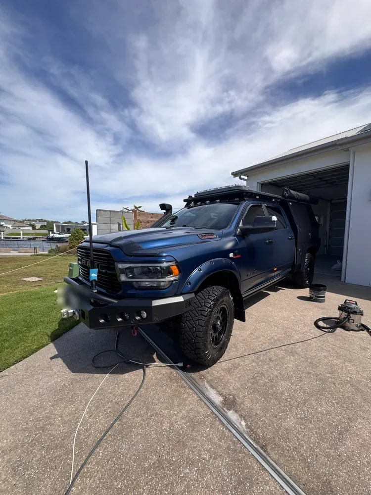 Blue RAM truck with bullbar and canopy washed and detailed on a driveway