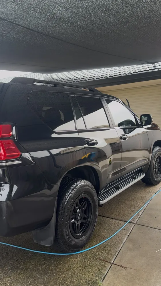 Black Toyota Prado detailed to a deep gloss under a carport
